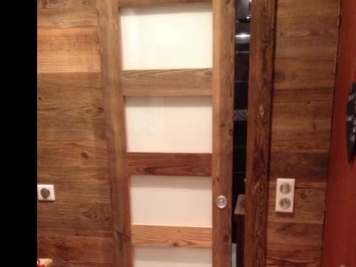 Porte coulissante en vieux bois et vitres blanches laquées